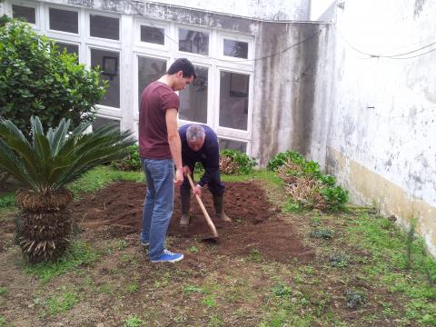 É cavada a horta e preparada a sementeira. trabalho realizado por um aluno e pelo funcionário da escola.